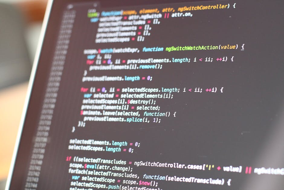 A close-up photograph of a computer screen displaying colorful lines of code, including syntax-highlighted JavaScript or similar programming language, with elements such as functions, variables, and c